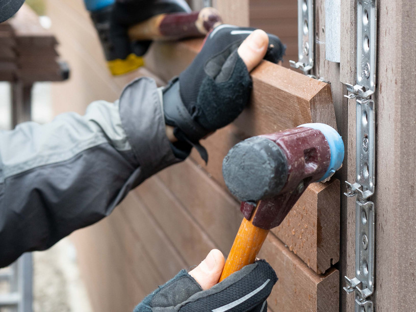 Nahaufnahme eines Handwerkwerkers bei der Montage eines Sichtschutz