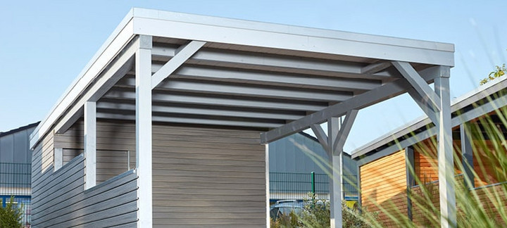 Carport mit Holzdach als Unterstand für ein geparktes Auto.