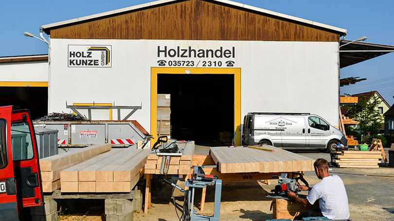 Bearbeitung von Holzbalken im Aussenbereich vor Holzlager