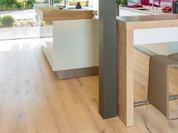 Die Küche ist mit hellem Holzlaminat ausgelegt. Eine Koch- und Essinsel mit drei Hockern lädt zum Verweilen ein.