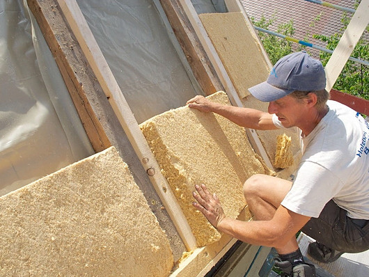 Verlegung von Holzfaserdämmplatten durch einen Handwerker