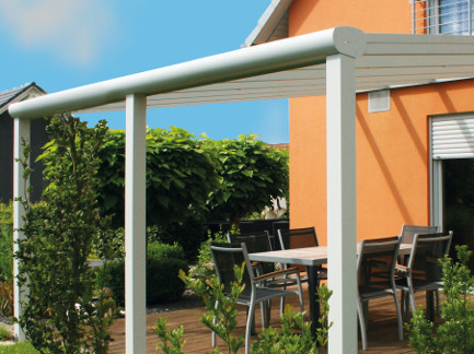 Überdachte Holzterrasse neben dem Gebäude.