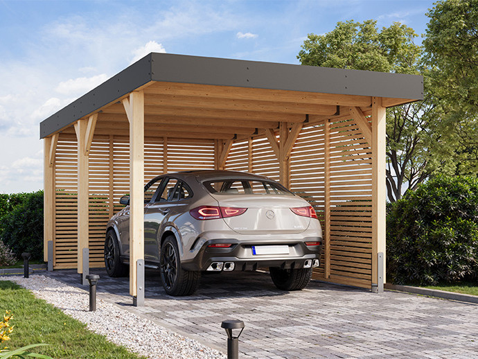 Einzelcarport aus Holz mit Lamellen-Seitenwänden und schwarzem Dach, in dem ein Mercedes auf gepflasterten Untergrund steht.