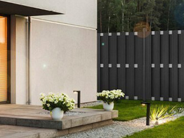 Grauer WPC-Zaun in der Nähe eines Hauses