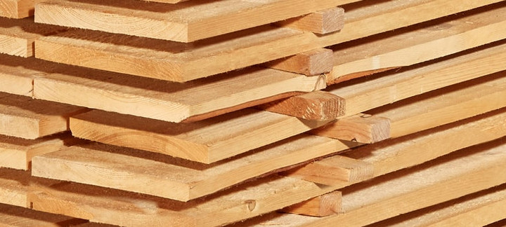 Gestapelte Schalbretter aus Holz mit sägerauer Oberfläche, ideal für den Bau- und Konstruktionsbereich.